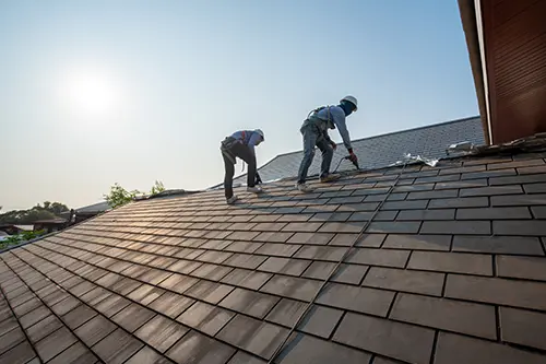 BAM Roofing & Construction—Roofers working on replacing roofing tiles on a roof in a Central IL residence.